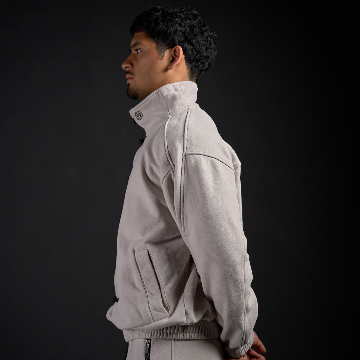 Tang Warmup Jacket in TWILIGHT bone, side profile on model | Village Hidden in Iron