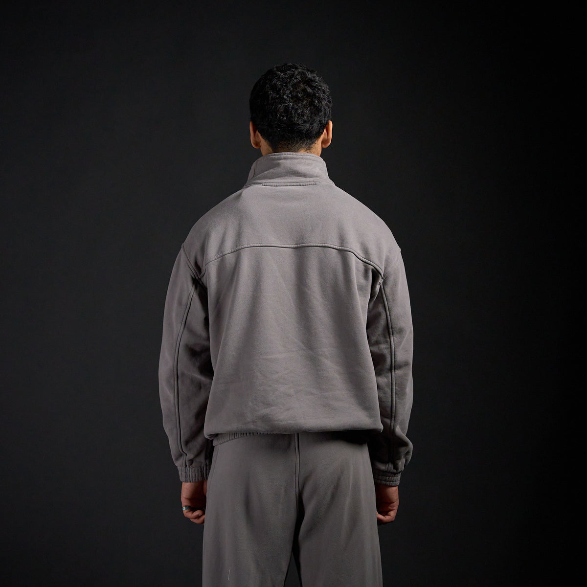 Tang Warmup Jacket in DARKSIDE charcoal grey, back view on model | Village Hidden in Iron