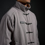 Tang Warmup Jacket in DARKSIDE charcoal grey, close-up of stand collar and frog closures | Village Hidden in Iron