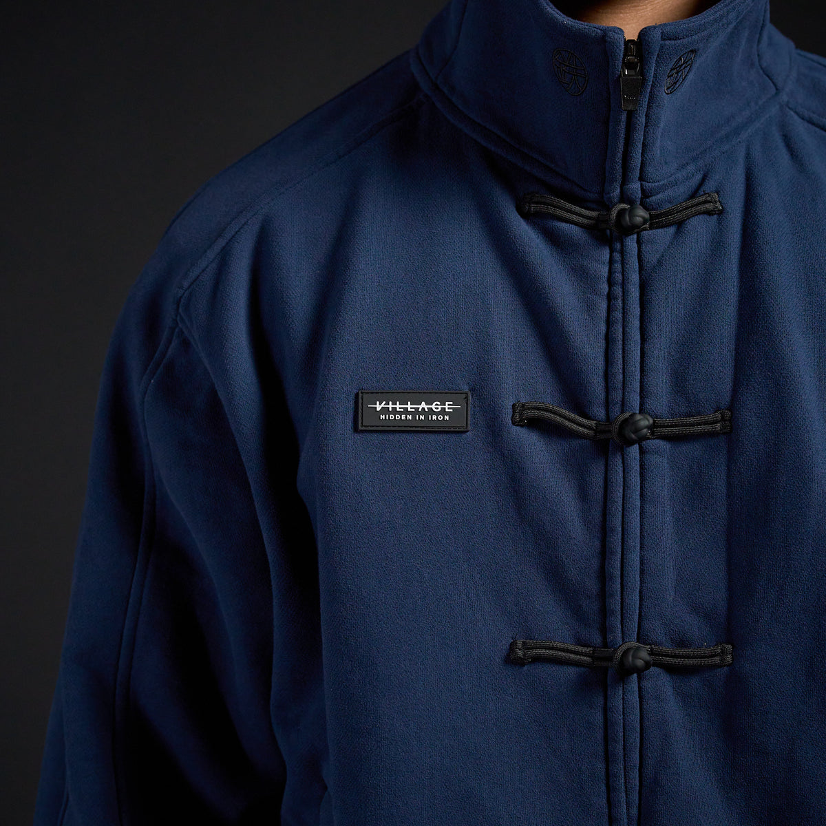 Tang Warmup Jacket in MIDNIGHT navy, close-up of frog closures and chest patch | Village Hidden in Iron