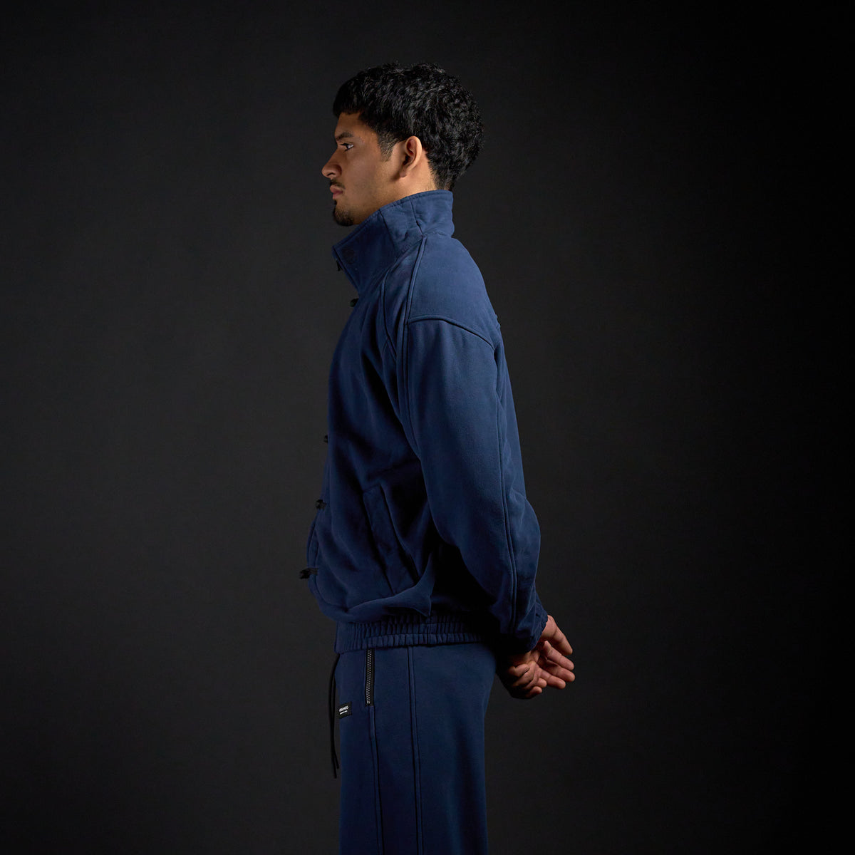 Tang Warmup Jacket in MIDNIGHT navy, side profile on model | Village Hidden in Iron